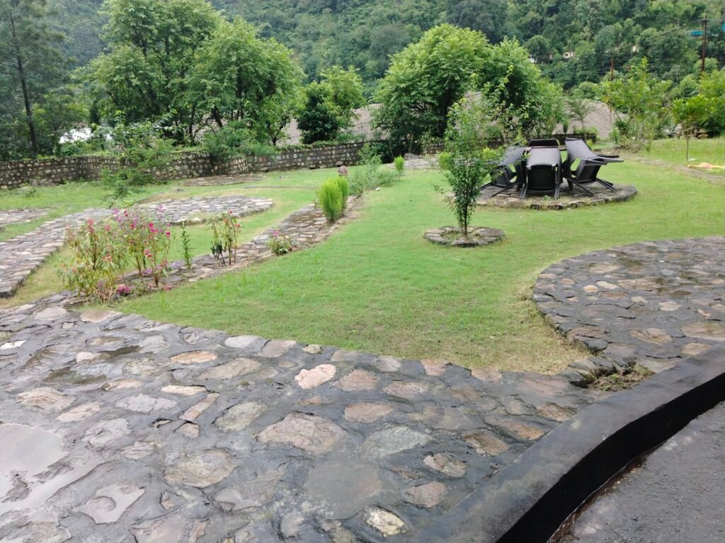 Open green lawn with stone pavement and garden furniture