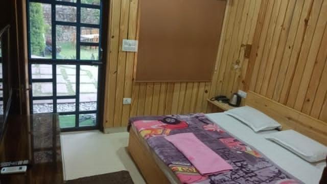 Wooden bedroom with window offering natural light and garden view.